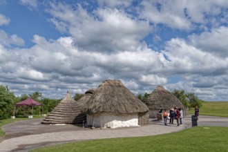 Tourists visit the replicas of Neolithic houses at the Stonehenge visitor centre. Amesbury,