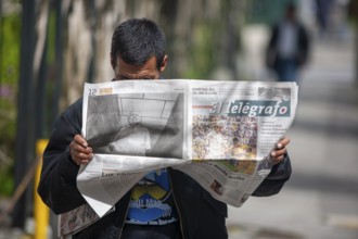 Man reading a newspaper in the street, City of Quito. Pichincha province, Ecuador, South America