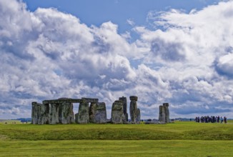 A group of tourists visits Stonehenge. The stone circle, a National Trust, UNESCO World Heritage