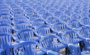 Many rows with a lot of blue pastic chairs