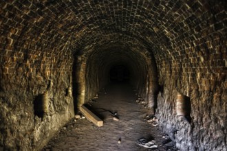 Grunge, spooky arched corridor in an abandoned brick building, urban exploration, haunted tunnel