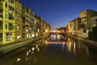 Girona city by night in Spain, waterside houses on the River Onyar, picturesque urban landscape in