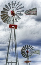 A vertical view of two wind wheels or wind pumps up close
