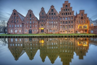 The historic salt warehouse reflected in the Trave river at dusk, seen in Lübeck, Germany