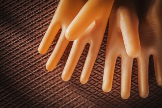 A pair of insulating gloves on a dielectric rubber mat