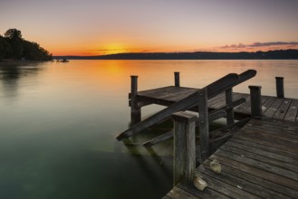 Wooden footbridge at Lake Starnberg near Bernried in Upper Bavaria in summer at sunrise