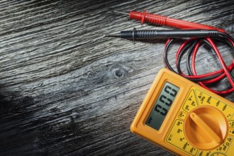 Electric multitester on wooden board