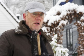 Portrait of an elderly man in snow at winter time