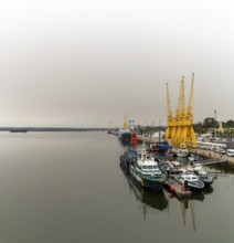 Huelva, Spain - 15 March, 2022: calm Rio Tinto River with harbor cranes and Guardia Civil police