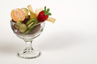 Fruit salad in a glass bowl on white background