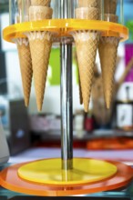 Waffle cones for ice cream put on stand. Ice cream shop. Bright colours. Sweet food