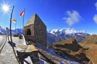 Steep turns are marked with red flags. Picturesque alpine road Grossglocknershtrasse. Bright sunny