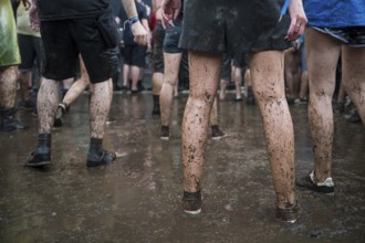 Dirty legs of people dancing in the mud during concert