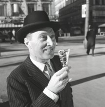 Ice cream in the 1960s. A well dressed gentleman in a suit and hat enjoys a ice cream on a sunny