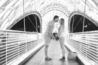 Young loving couple kissing on the bridge of Peace in Tbilisi, Georgia