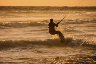 Single surfer at sunset on a calm ocean