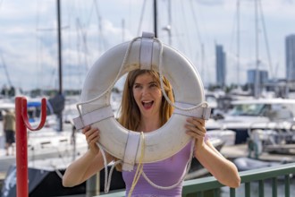 A gorgeous redhead model enjoys the perfect summer weather at a local marina, surrounded by boats