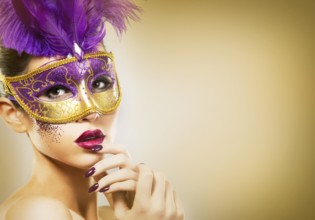 Beautiful woman with dramatic mekaup and pruple lipstick wearing puprle mask. Light background.
