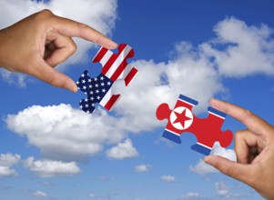 Two hands each holding a puzzle piece, silhouette, confrontation, rapprochement, war, trade war,