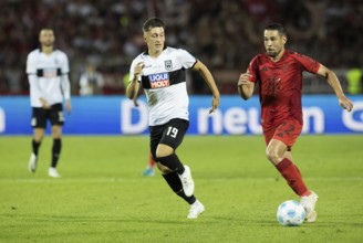 Football match, Raphael GUERREIRO FC Bayern Munich right on the ball in a duel with Jonathan MEIER