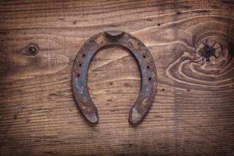 Single old horseshoe on vintage wooden board happy concept