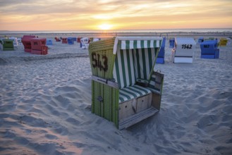 Single green beach chair on the beach at sunset with sea view, langeoog, east frisia, germany