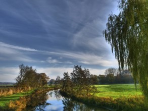 A calm river under a clear sky with few clouds and surrounded by trees, Borken, münsterland,