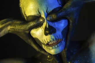 Isolated on black, closeup picture, toned yellow and blue, spooky young blonde caucasian pretty