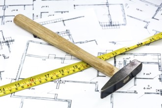 Hammer and yardstick lying on construction plan