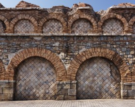 Old stone wall with brick arches antique rustic architectural texture