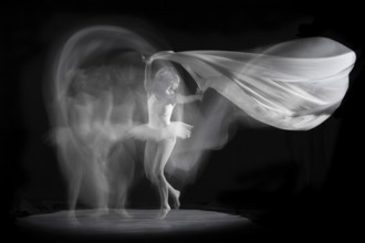 Ballerina in motion with flowing fabric, elegant and graceful in an artistic image, long exposure,