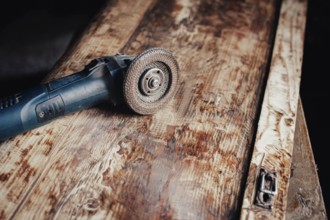 Angle grinder placed on a timeworn wooden board showcasing detailed carpentry