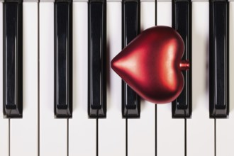 Detail of piano keyboard and red heart