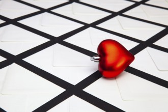 Composition with white envelopes and red heart on the table. The photo suitable for various