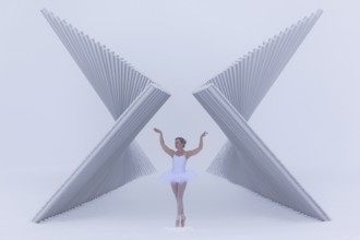 Ballerina poses gracefully between a futuristic sculpture in winter in sub-zero temperatures,