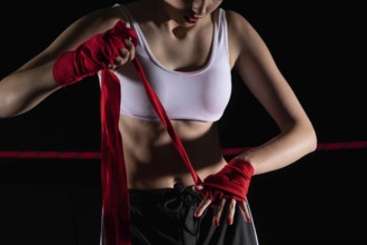 The athlete wraps her hands with a boxing bandage. Preparation for an important MMA fight. The