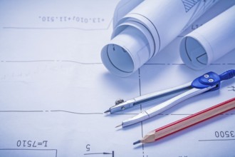 Compass pencil and two rolled up white blueprints copyspace