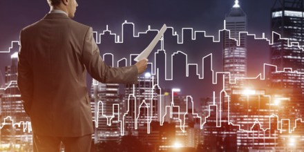 Man architect or engineer presenting construction concept and holding documents in hand