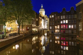 Night view of buildings and boats along the canal in Amsterdam, Netherlands