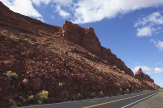 The magnificent American road passes between rocks of red sandstone