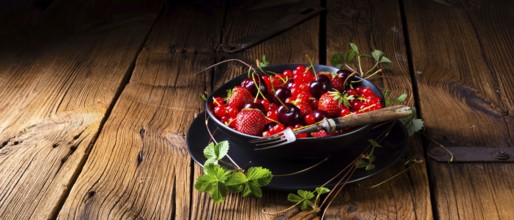 Bowl with different fruits such as strawberry, red currant, and cherry