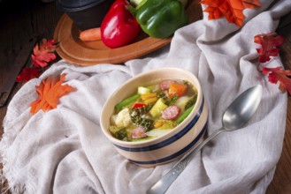 Delicious autumn vegetable soup with sausage and bacon
