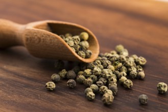 Green Peppercorns on wooden background