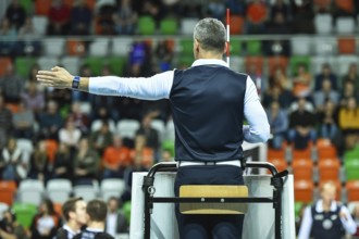 Volleyball first referee indicates a point for the team on the left