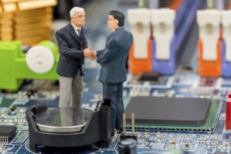 Two managers are having a conversation standing on the circuit board of a computer