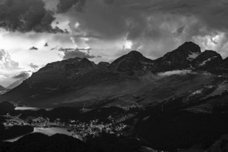 Beautiful Aerial View over Alpine Lakes and Swiss Alps and Cityscape in Sunset and Storm Clouds