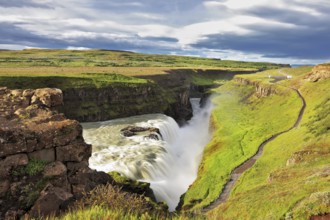 Grand Gullfoss in Iceland. Summer sunny day. Roaring water lit by the morning sun. The river banks
