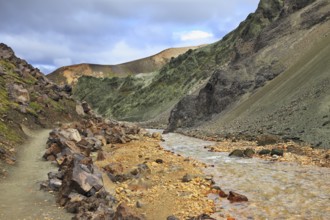 Steep mountain slopes, the path and the creek in the gorge. National Park Landmannalaugar in