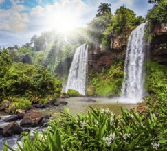Two rapid waterfalls from the Iguazu Falls. Hot tropical sun illuminates the rumbling waterfalls.
