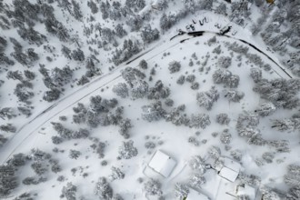 Drone scenery of car vehicles covered in snow on parked on a frozen road. Extreme weather snowstorm